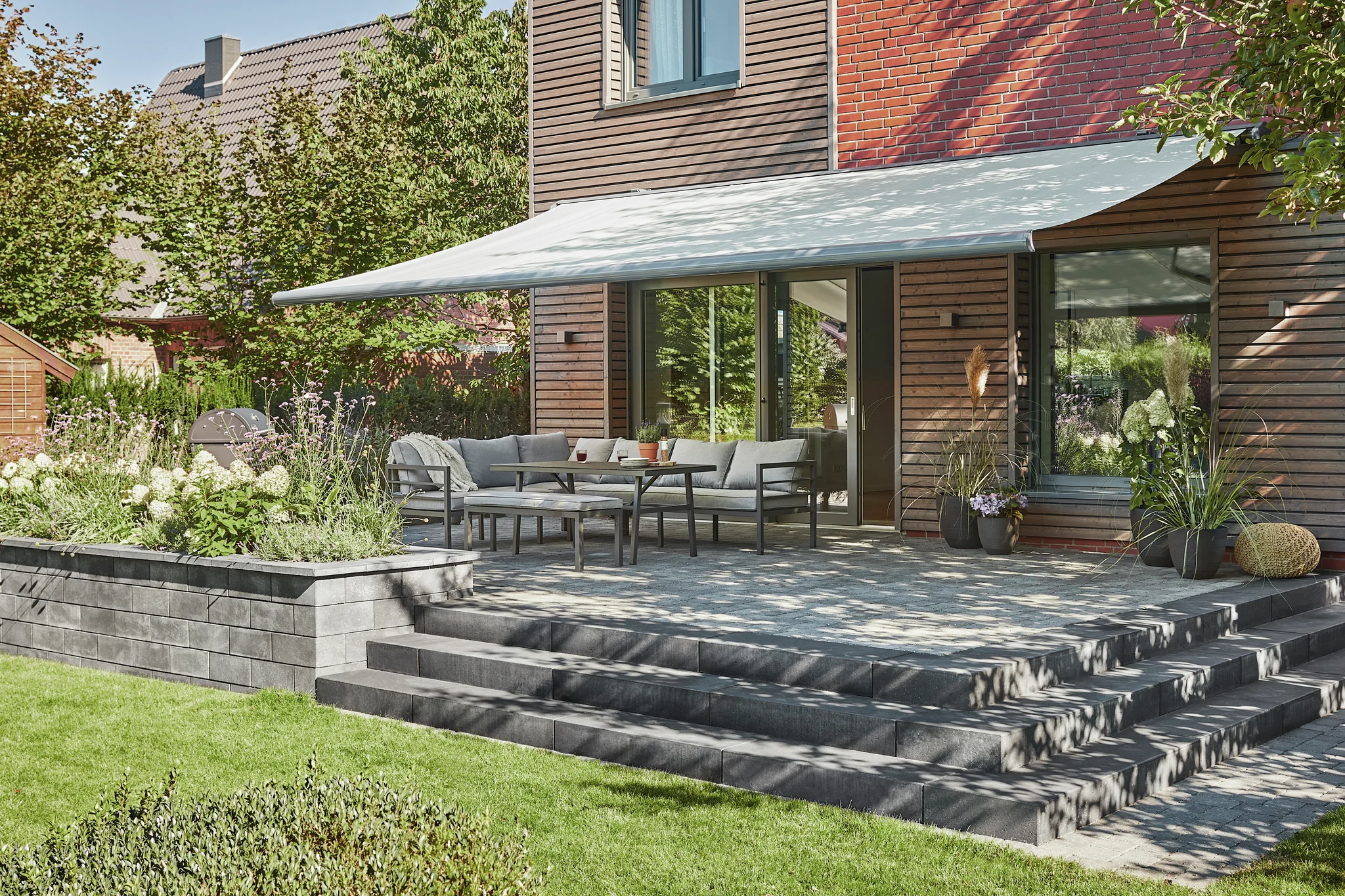 RolloMax Wien - Rollläden, Markisen, Jalousien Gelenkarmmarkise über moderner Terrasse - Sonnenschutz und Markisen vom Fachmann in Wien - RolloMax